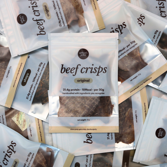 Package of Arthur's Jerky beef crisps on a beige background; 21.4g protein, 109kcal